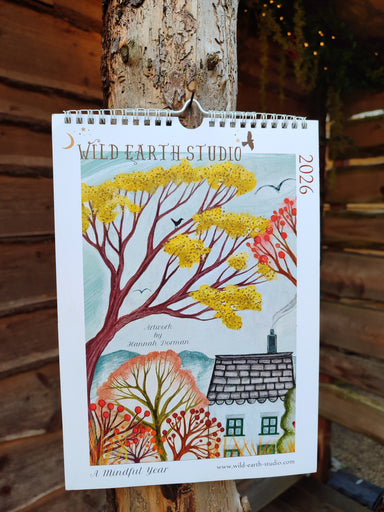 2026 Wild Earth Studio calendar with nature-themed design on a wooden background