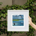 Framed primt of Swallows and Sails,  of birds over water with sailboats, held by a hand against a leafy background. Strangford Lough, Northern Ireland 