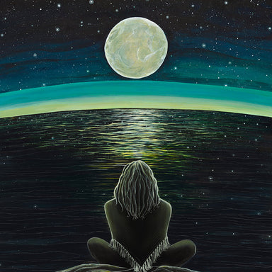 Person sitting on a rock gazing at a large moon over a starry night sky.